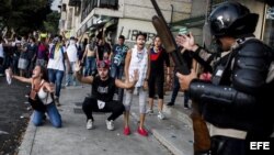 Miembros de la Policía Nacional Bolivariana (PNB) enfrentan a manifestantes hoy, sábado 15 de febrero de 2014, en la Plaza Altamira, en Caracas (Venezuela).