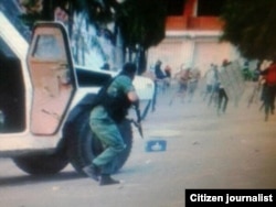 Un Guardfia Nacional se baja escopeta en mano a disparar contra los manifestantes en Barquisimeto.