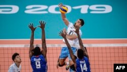 Nicolás Bruno de Argentina contra los cubanos Livan Osoria y Eduardo Goide en la final de Voleibol en Lima 2019. AFP/ Ernesto Benavides