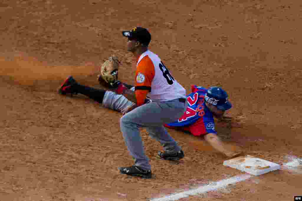 Ramon Lunar (i), de Villa Clara de Cuba, intercepta una pelota en primera base ante Juan Perez (d) de Tigres del Licey de República Dominicana hoy, lunes 3 de febrero de 2014, durante el tercer día de la Serie del Caribe 2014, en el Estadio Nueva Esparta, en Margarita (Venezuela).&nbsp;